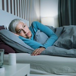 Frau liegt im Bett und schläft nicht