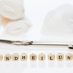 Wundheilung auf Spielsteine geschrieben mit medizinischen Instrumenten im Hintergrund