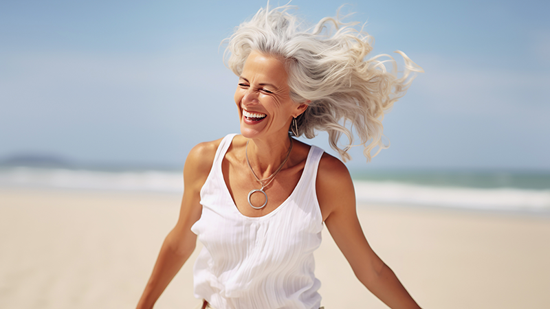 Frau mit grauen Haaren am Strand