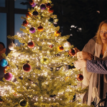 Ältere und jüngere Frau bewundern einen schönen Weihnachtsbaum.