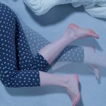 Frau bewegt in der Nacht ihre Beine im Bett