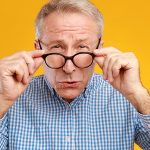 Älterer Mann versucht trotz Brille zu sehen. Hat aber Schwierigkeiten