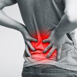 Mann hat Schmerzen im unteren Rücken. Dieser Bereich ist rot gekennzeichnet