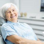 Lächelnde Frau auf dem Zahnarztstuhl