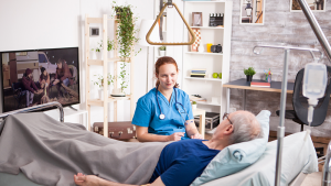 Pflegerin am Bett eines Bewohners