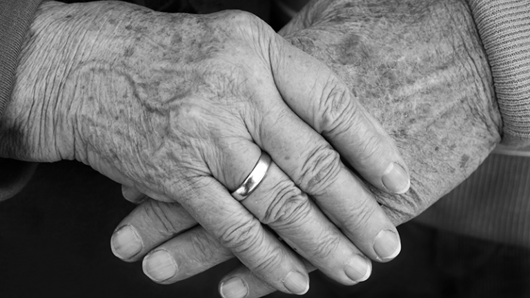Zwei ältere Hände berühren sich