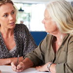 Tochter schreibt mit Mutter Testament