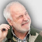 Älterer Herr führt Wattestäbchen mit schmerzverzerrtem Gesicht in Ohr ein.