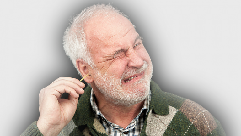 Älterer Herr führt Wattestäbchen mit schmerzverzerrtem Gesicht in Ohr ein.