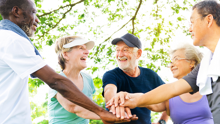 Ältere Menschen strecken Hände in der Mitte zusammen