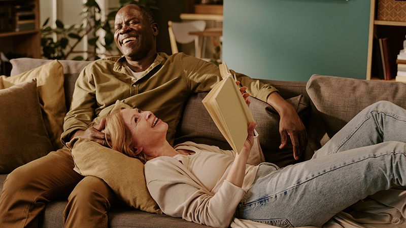 Frau auf Schoss von Mann liegend auf dem Sofa