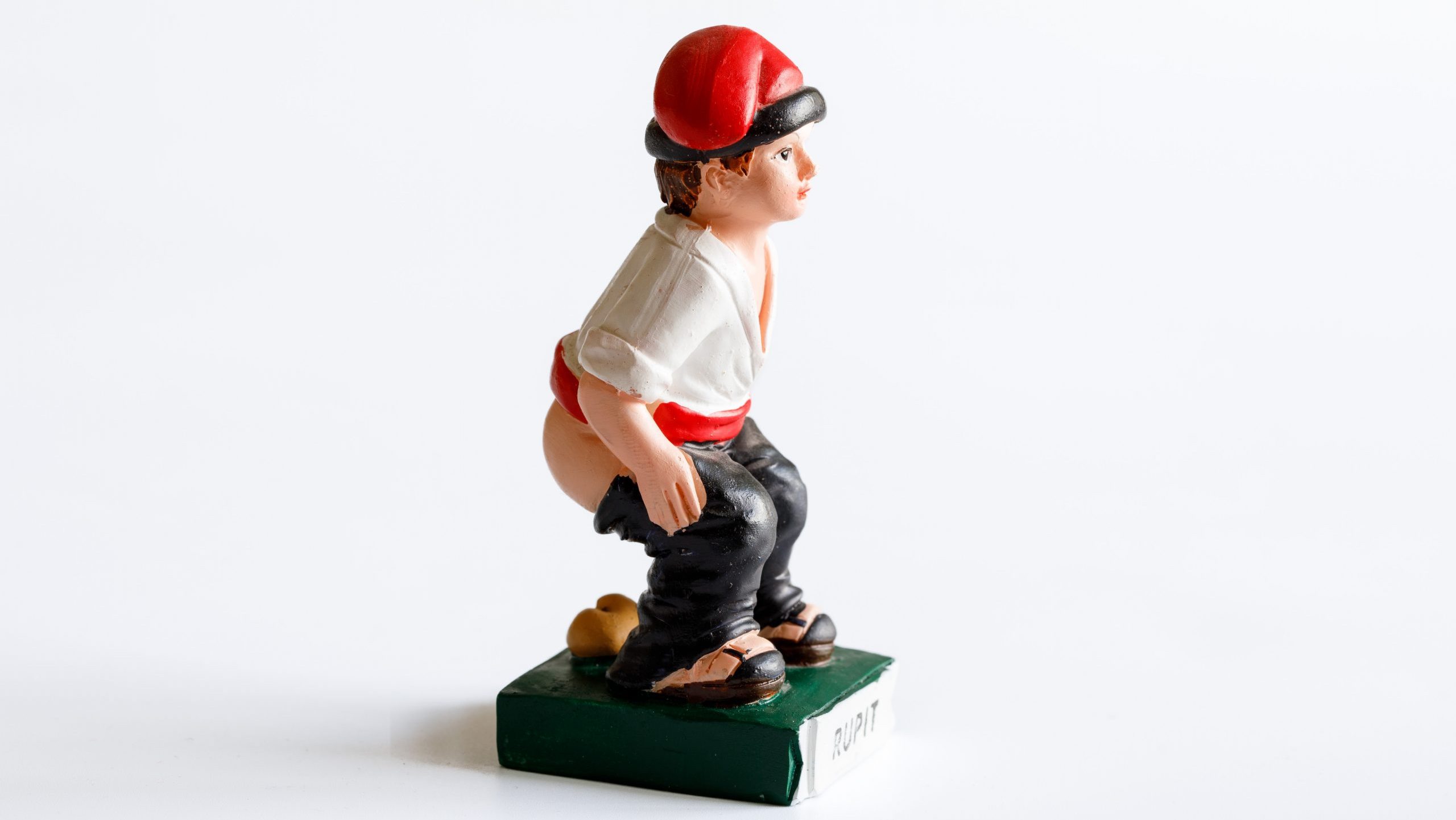 Caganer, originally character in Catalan mythology, nativity figurine in detail of man doing poop